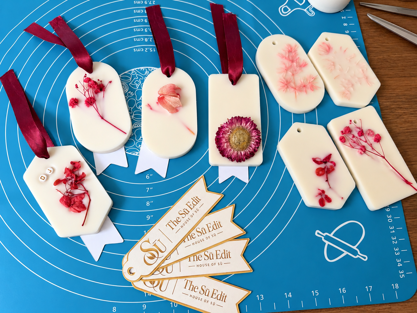 Sū Botanical Wax Sachets with dried botanicals and burgundy ribbon